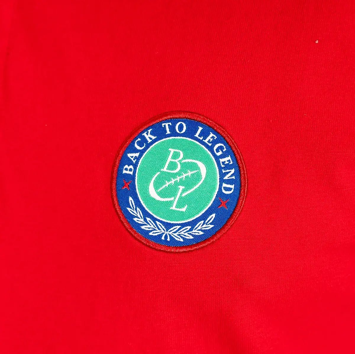 Polo homme rouge 100% coton jersey peau de pêche BACK to LEGEND (zoom badge)