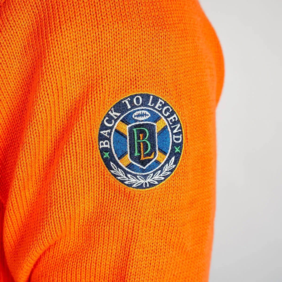 Pull orange full zip torsadé pour homme BACK to LEGEND (zoom sur le badge brodé)
