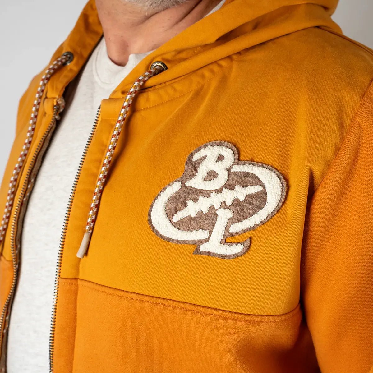 Sweat à capuche ocre en molleton gratté bi matière (zoom poitrine et col)